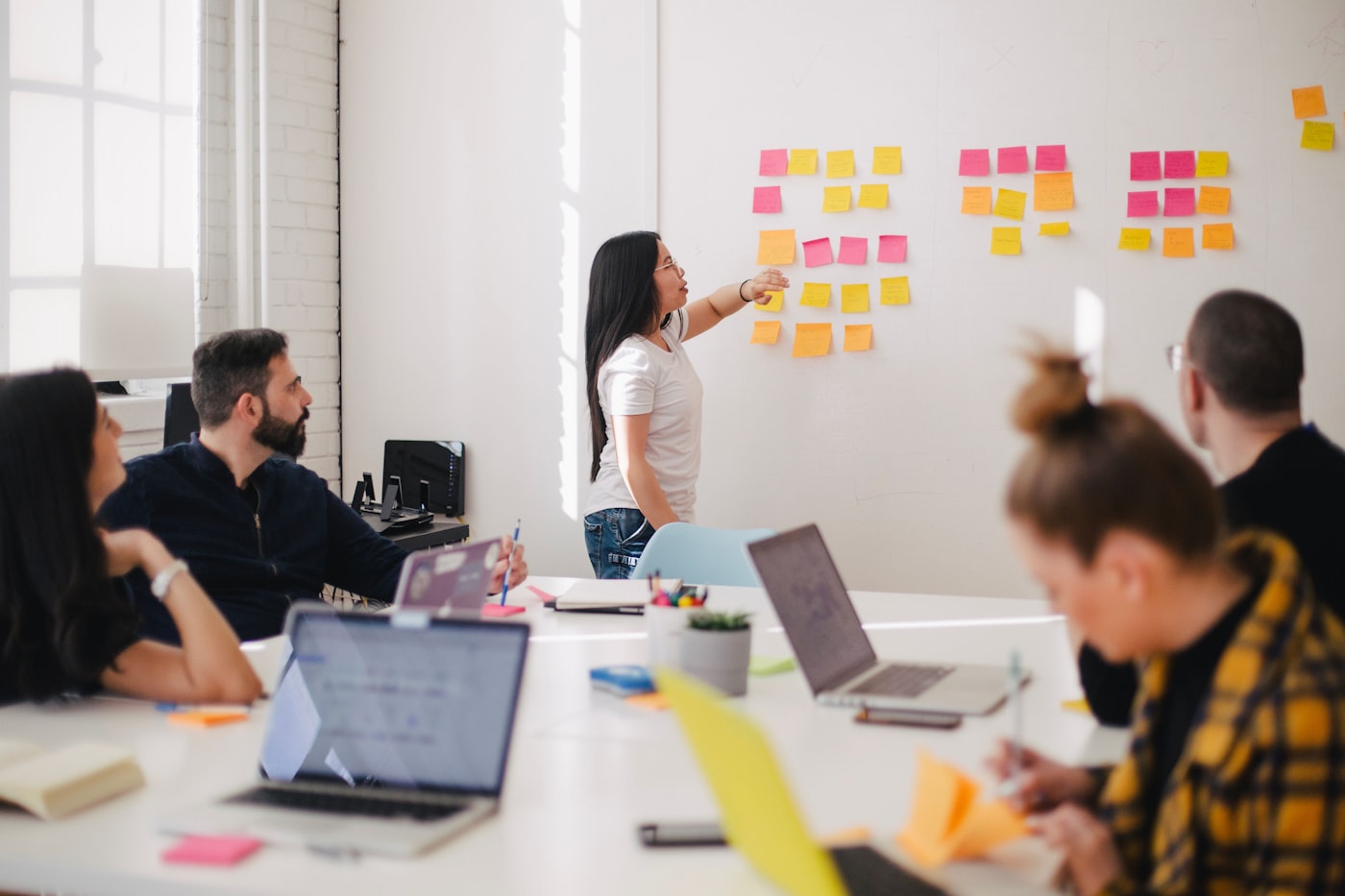 Equipo de trabajo planificando un embudo de captación de clientes con notas adhesivas sobre una pared blanca